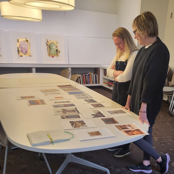 Curator Mary Statzer and Art History PhD student Eleanor Kane overlook a selection of images representing artworks to include in the upcoming exhibition.
